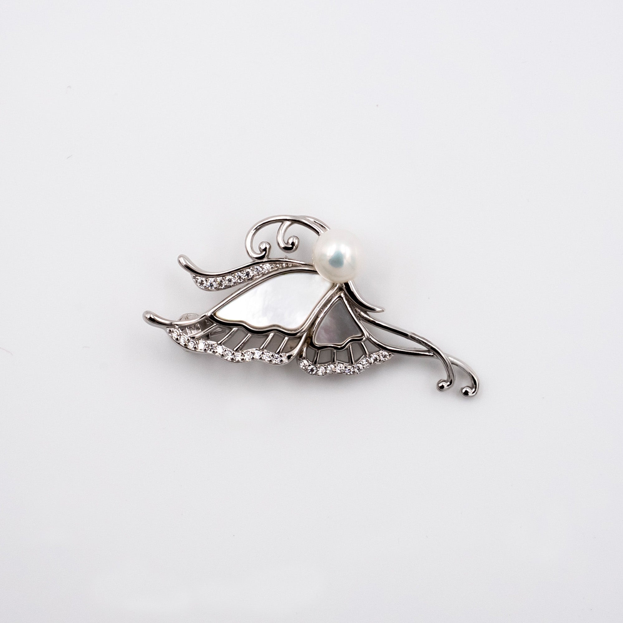 A silver-toned butterfly brooch featuring a white pearl at its center and small clear rhinestone accents, displayed on a clean white background.